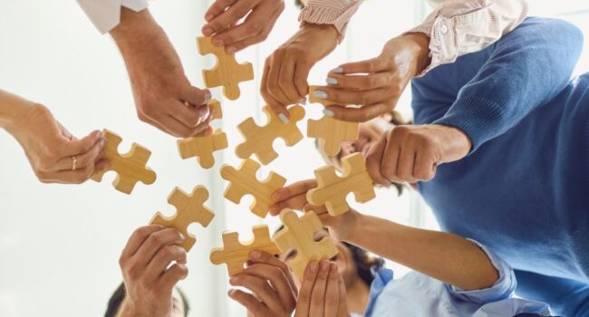 people holding puzzle pieces